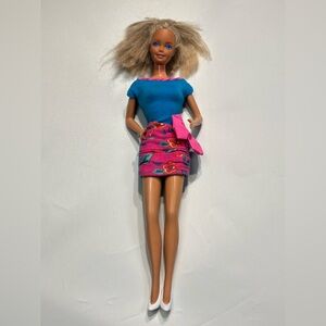 1980s Barbie dressed in a 1990s bright blue and hot pink floral dress.